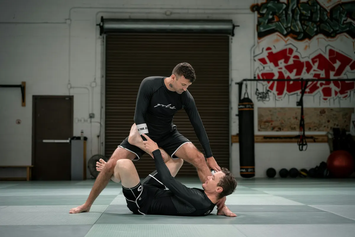 Zwei Grappler drillen Guard-Arbeit im No-Gi auf der Matte